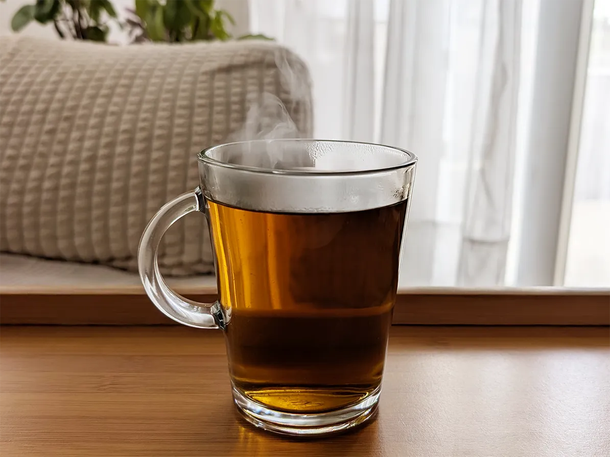 tasse avec décoction de kinkéliba posée sur une surface en bois