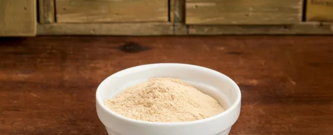 bienfaits de la poudre de baobab dans un bol en céramique posé sur une table en bois