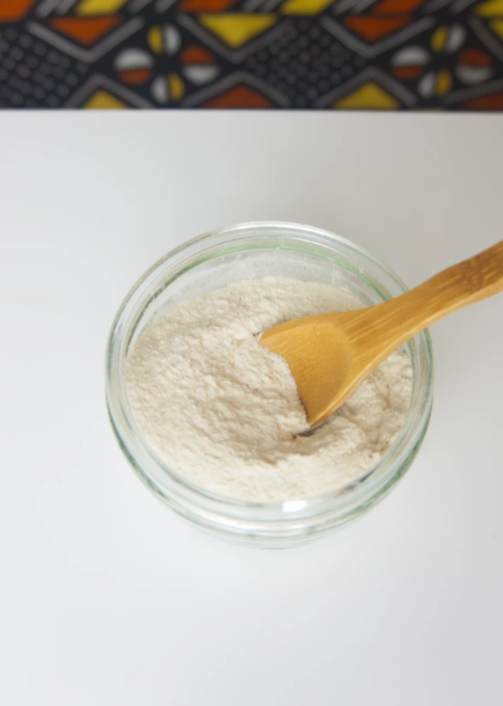 poudre de baobab dans un pot en verre posé sur une table blanche